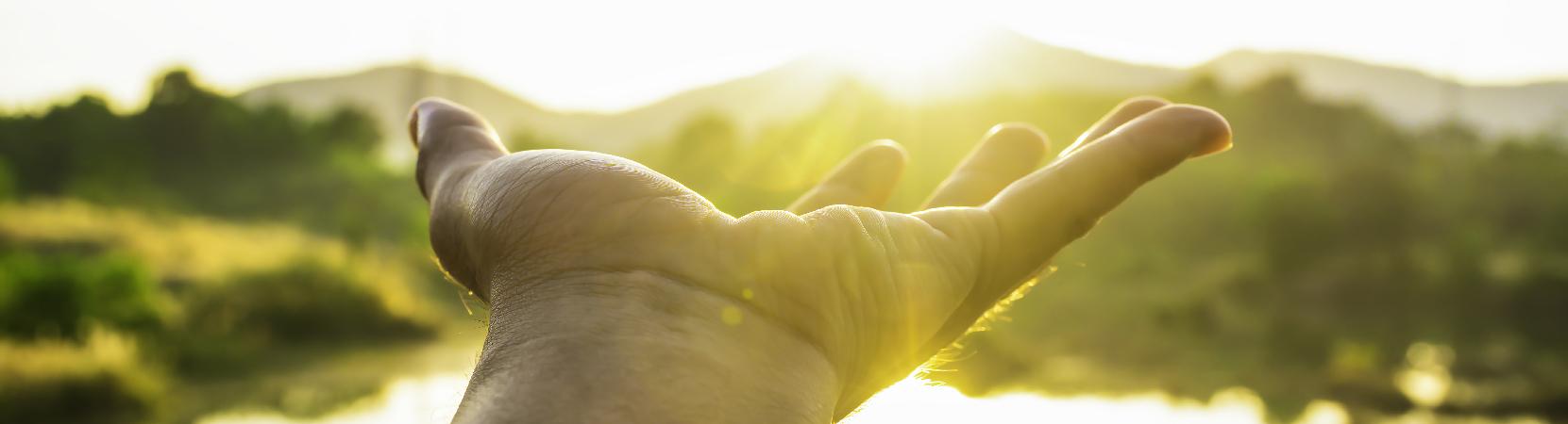 Energie, main devant le soleil